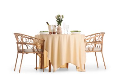 Beyaz arka planda çiçeklerle servis edilen restoran masası.