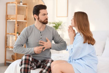 Yatak odasında kocasından özür dileyen genç bir kadın evlilik yüzüğünü parmağından çıkarıyor.