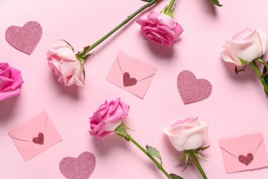 Gül çiçekli kompozisyon, dekoratif zarflar ve pembe arka planda parıldayan kalpler. Sevgililer Günü kutlaması