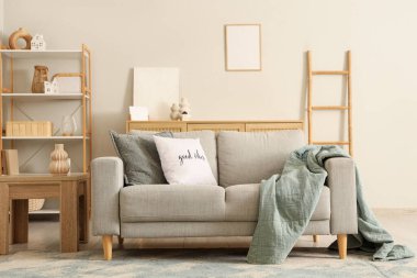 Gri kanepe, merdiven ve raf ünitesiyle aydınlık oturma odasının içinde.