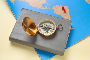 Bej arka planda not defteri ve haritası olan pusula, yakın plan. Güzergah kavramı