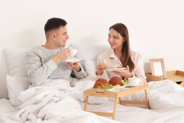 Genç çift evde kahvaltı yapıyor.