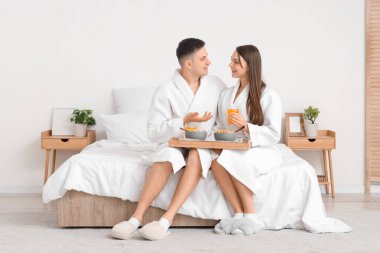 Meyve suyu ve mısır gevreği yüzüklü mutlu çift kahvaltısını yatak odasında yapıyor.