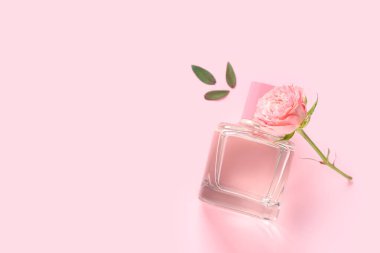 Bir şişe güzel gül ve pembe arka planda yapraklar.