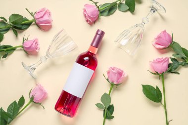 Bir şişe pembe şarap ve sarı arka planda güzel güller.