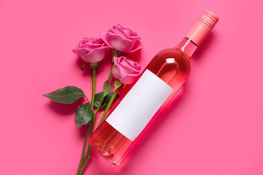 Bir şişe pembe şarap ve arka planda güzel güller.