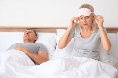 Sinirli olgun kadın yatak odasına kulak tıkacı ve horlayan kocası koyuyor.