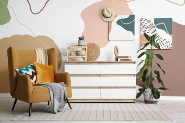 Klozet, koltuk ve resimlerle dolu bir oturma odası.