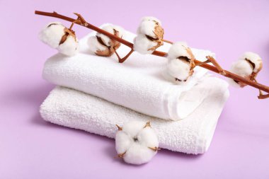 Pembe arka planda temiz havlular ve pamuk dalı