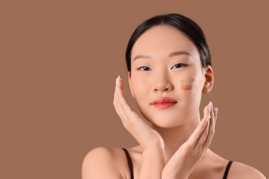 Kahverengi arka planda tonsal temel örnekleri olan güzel Asyalı kadın.