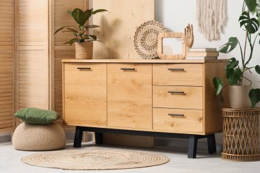 Odanın içinde ahşap tuvalet, katlanır ekran ve bitkiler var.