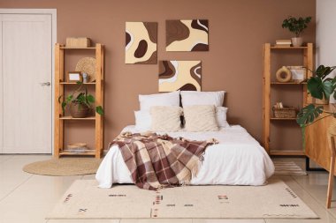 Tabloları, raf üniteleri ve kapısı olan şık bir yatak odası.