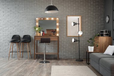 Masası, lambası ve kanepesi olan bir kuaför salonu.