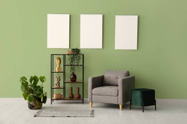 Rafa kaldırma ünitesi, koltuk ve yeşil duvardaki boş posterler.