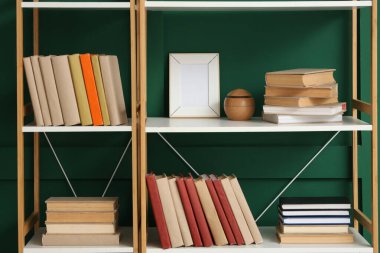 Kitaplı raflar ve yeşil duvarın yanındaki dekorasyon odası. Yakın çekim.