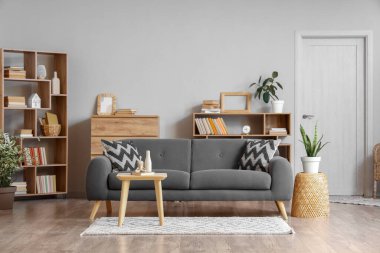 Oturma odasındaki rahat kanepe, sehpa ve kitaplıklar.