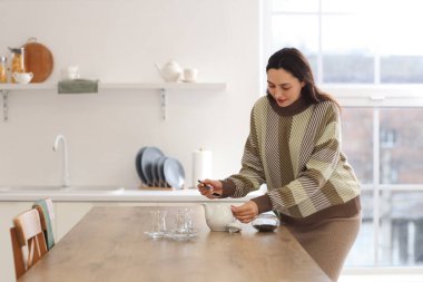 Genç bayan mutfakta Türk çayı hazırlıyor.