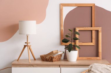 Kitaplı sepet, bitki ve lamba tuvalette.