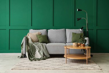 Oturma odasında kanepe, masa ve lamba var.