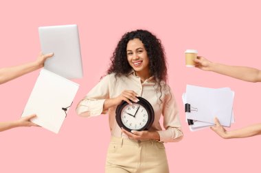 Pembe arka planda yapacak çok işi olan genç bir Afro-Amerikalı kadın. Zaman yönetimi kavramı
