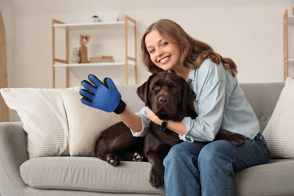 Young woman with pet glove and her cute dog at home