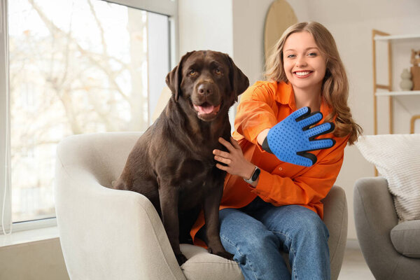 Young woman with pet glove and her cute dog at home