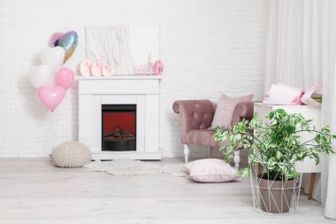 Sevgililer Günü kutlamaları için koltuğu, şöminesi ve süslemeleri olan aydınlık oturma odasının içinde.