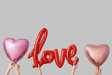 Kelimesi kelimesine aşık kadınlar ve arka planda balonlar. Sevgililer Günü kutlaması