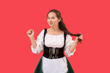 Kırmızı arka planda geleneksel kostümlü genç bir kadın. Aziz Patrick Günü kutlaması