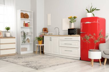 Kırmızı buzdolabı ve beyaz tezgahlı şık bir mutfak.