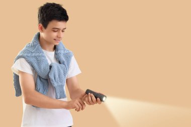 Bej arka planda parlayan el feneri olan genç bir çocuk ve metin için yeri var.