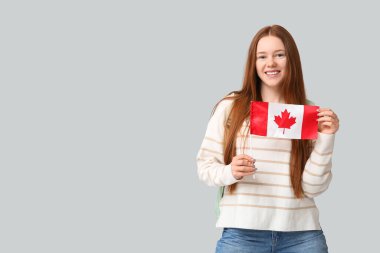 Gri arka planda Kanada bayrağı taşıyan bayan öğrenci