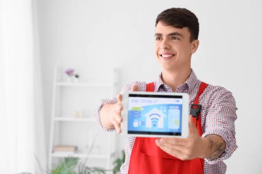 Evde alarm sistemi yüklü tablet gösteren erkek işçi