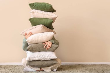 Şık bir odada yumuşak yastıkları olan genç bir kadın.