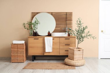 Göğüs, lavabo ve ayna dolu hafif bir banyo.