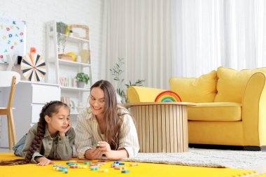 Kadın konuşma terapisti ve ofisinde mektupları olan küçük bir kız.