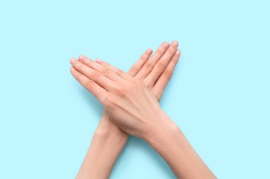 Mavi arka planda kalp hareketi gösteren kadın elleri