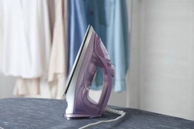 Gemide elektrikli ütü ve ışık odasında elbise askısı var.