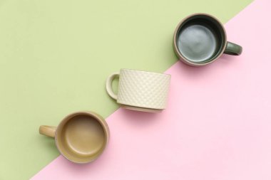 Renk arkaplanında farklı seramik bardaklar