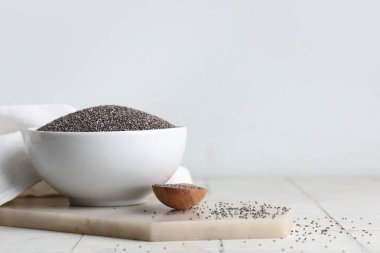 Kase ve tahta kaşık beyaz fayans üzerinde chia tohumları