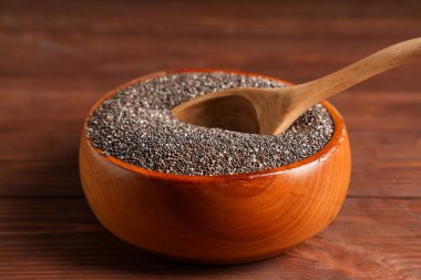 Ahşap zemin üzerinde chia tohumları ve kaşık ile kase