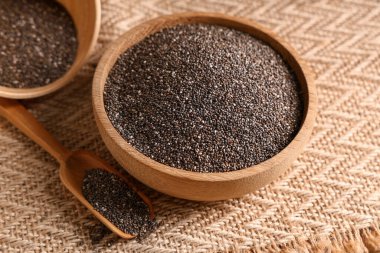 Kâseler ve kepçeyle peçetenin üzerinde chia tohumları, yakın plan.