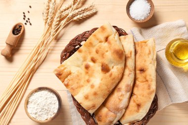 Tahta arka planda lezzetli lahanalar, malzemeler ve buğday dikenleriyle dolu bir sepet.