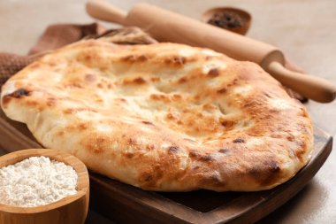 Lezzetli lavaşlı ahşap tepsi ve bir kase un, yakın plan.