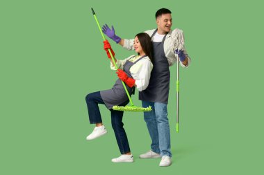 Hoş bir genç çift yeşil arka planda yer paspaslarıyla eğleniyor.