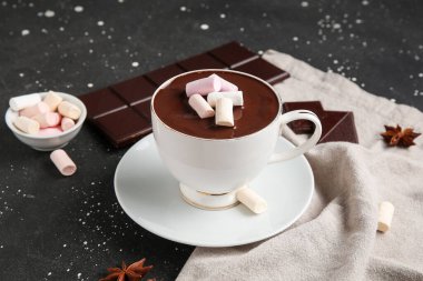 Bir fincan kremalı sıcak çikolata ve siyah grunge arka planda yıldız anason.