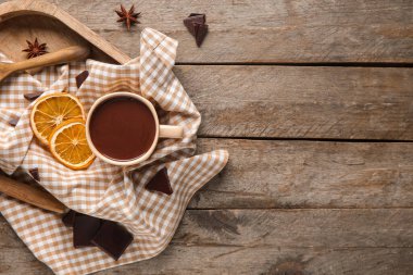 Kurumuş portakal dilimli bir fincan sıcak çikolata ve ahşap arka planda yıldız anason.
