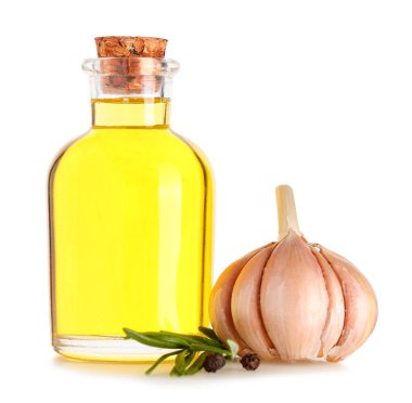 Bir şişe taze sarımsak yağı, biber ve beyaz arka planda biberiye.