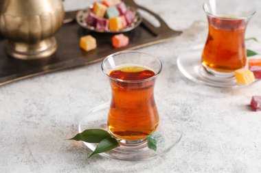 Hafif arkaplanlı ve yapraklı bir bardak Türk çayı.