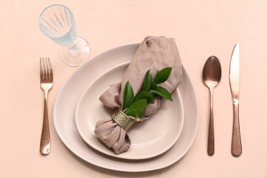 Bej arka planda taze yapraklarla güzel bir masa.